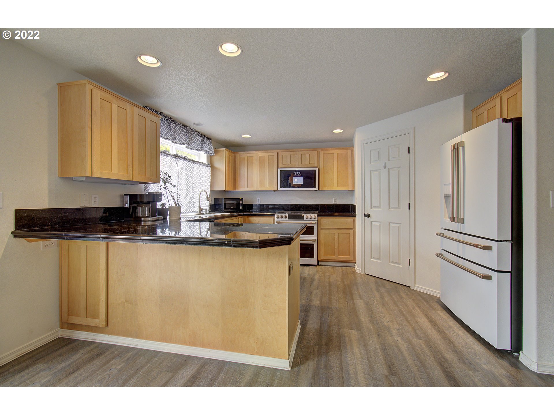 810 Raven Drive Ridgefield, WA 98642 - Photo 10 of 32 a kitchen with stainless steel appliances granite countertop a refrigerator sink and cabinets