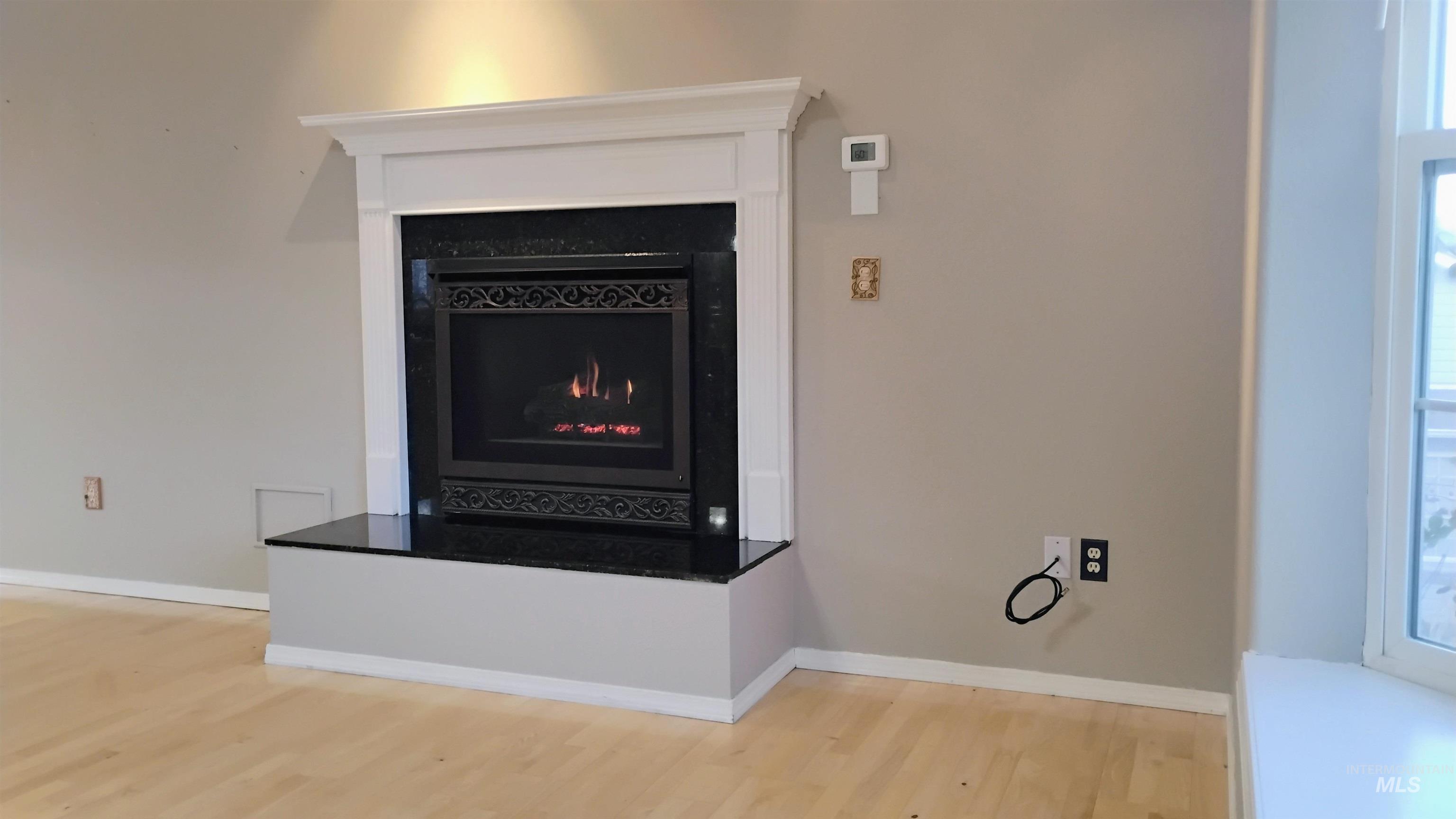 2242 Chukar Lane Clarkston, WA 99403 - Photo 9 of 41 Detailed view of a warm lit fireplace and wood finished floors
