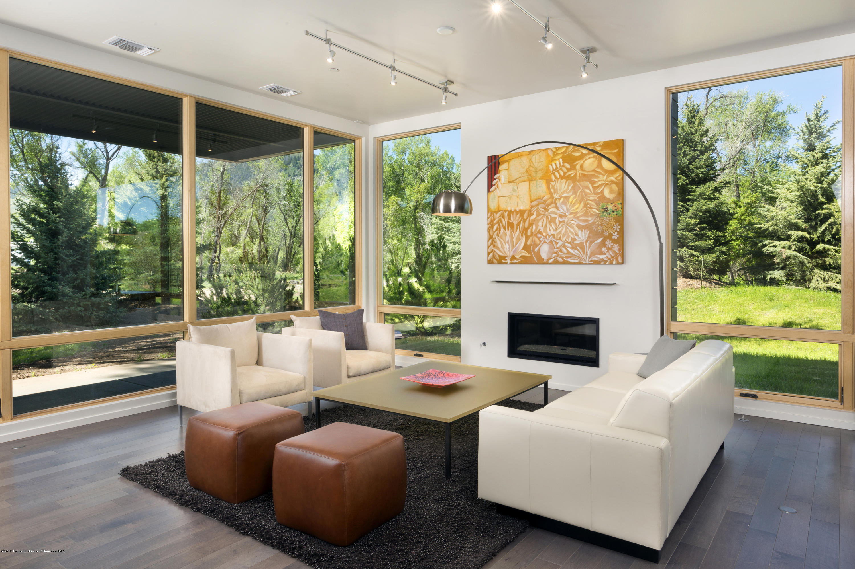 a living room with fireplace furniture and a large window