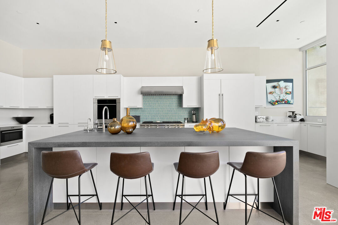 1550 Casale Road Pacific Palisades, CA 90272 - Photo 11 of 29 a kitchen with stainless steel appliances a counter and chairs