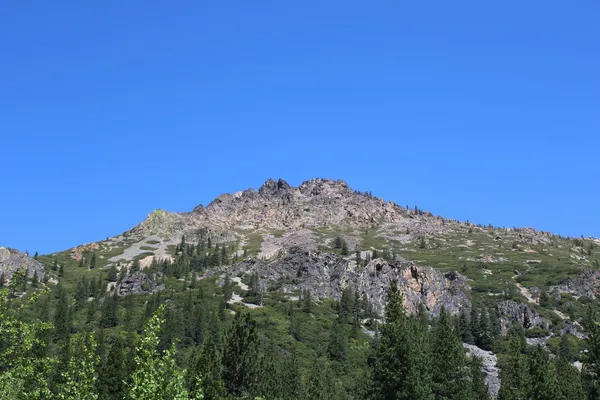 a view of a large building with mountains in the background