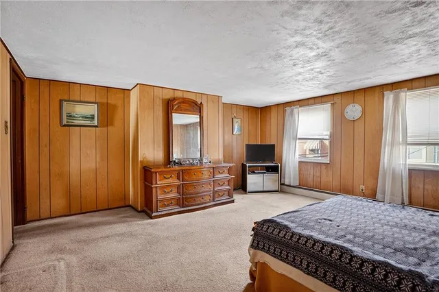 a spacious bedroom with a bed and wooden floor
