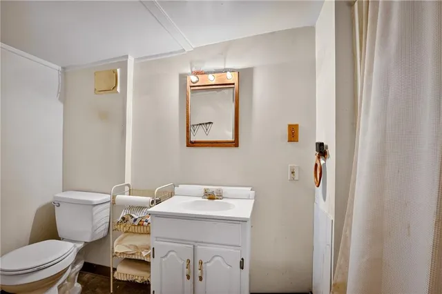 a bathroom with a sink toilet and mirror