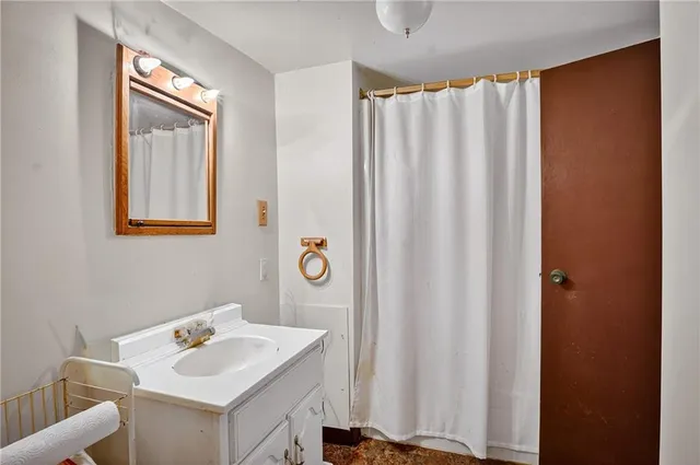 a bathroom with a sink a mirror and a shower curtain