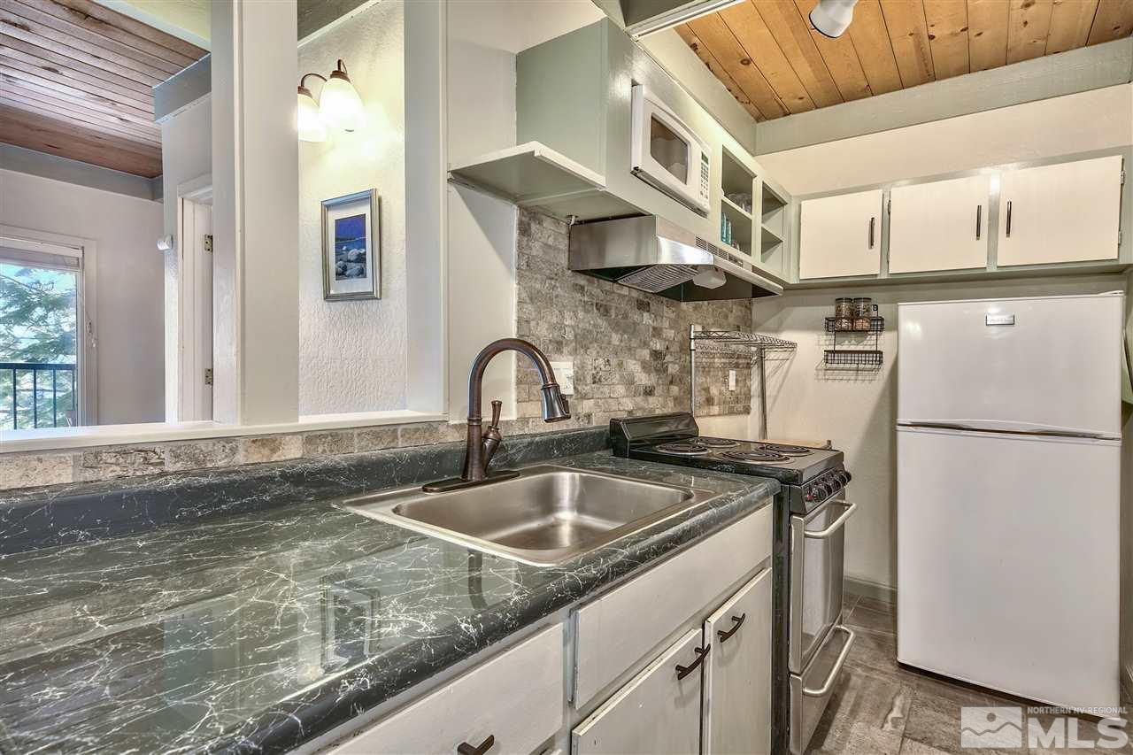 331 Tramway Drive, Unit 4 Stateline, NV 89449 - Photo 9 of 18 a kitchen with stainless steel appliances granite countertop a sink a refrigerator and a granite counter tops with a white cabinets