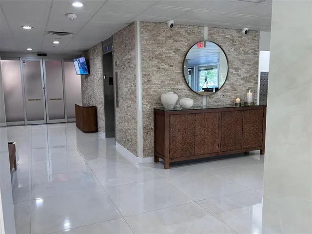 a view of a lobby with floor to ceiling windows and a chandelier