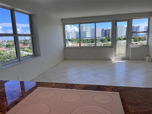 a living room with stainless steel appliances kitchen island granite countertop furniture and a large window