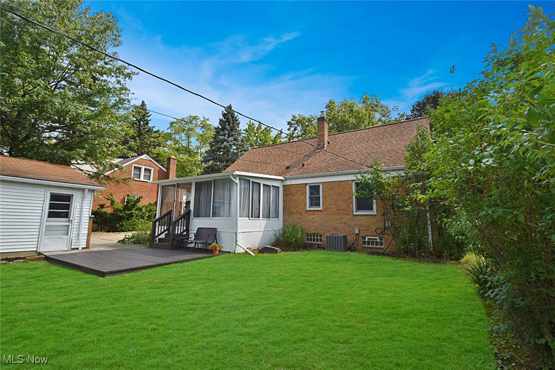 1388 Ford Road Lyndhurst, OH 44124 - Photo 37 of 39 Back of house featuring a sunroom, a deck, a lawn, and central AC unit