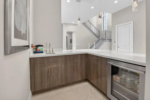 a kitchen with stainless steel appliances granite countertop a stove top oven a sink dishwasher a refrigerator and a dining table with wooden floor