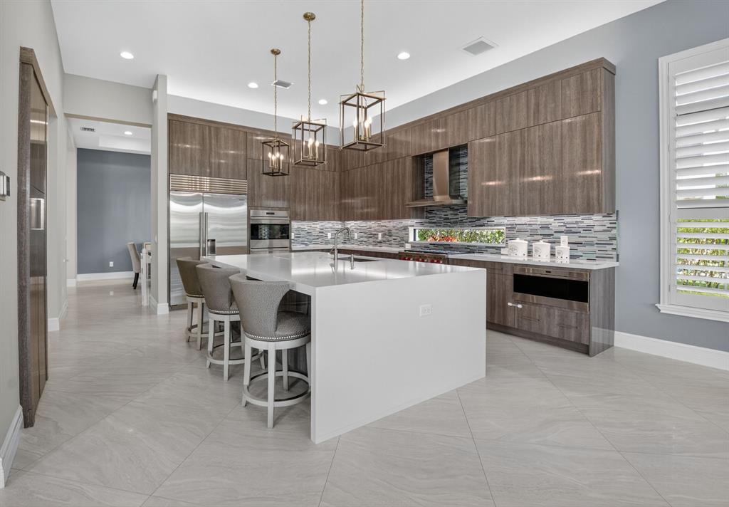 9294 Biaggio Road Boca Raton, FL 33496 - Photo 16 of 80 a kitchen with stainless steel appliances granite countertop a stove top oven a sink dishwasher a refrigerator and a dining table with wooden floor