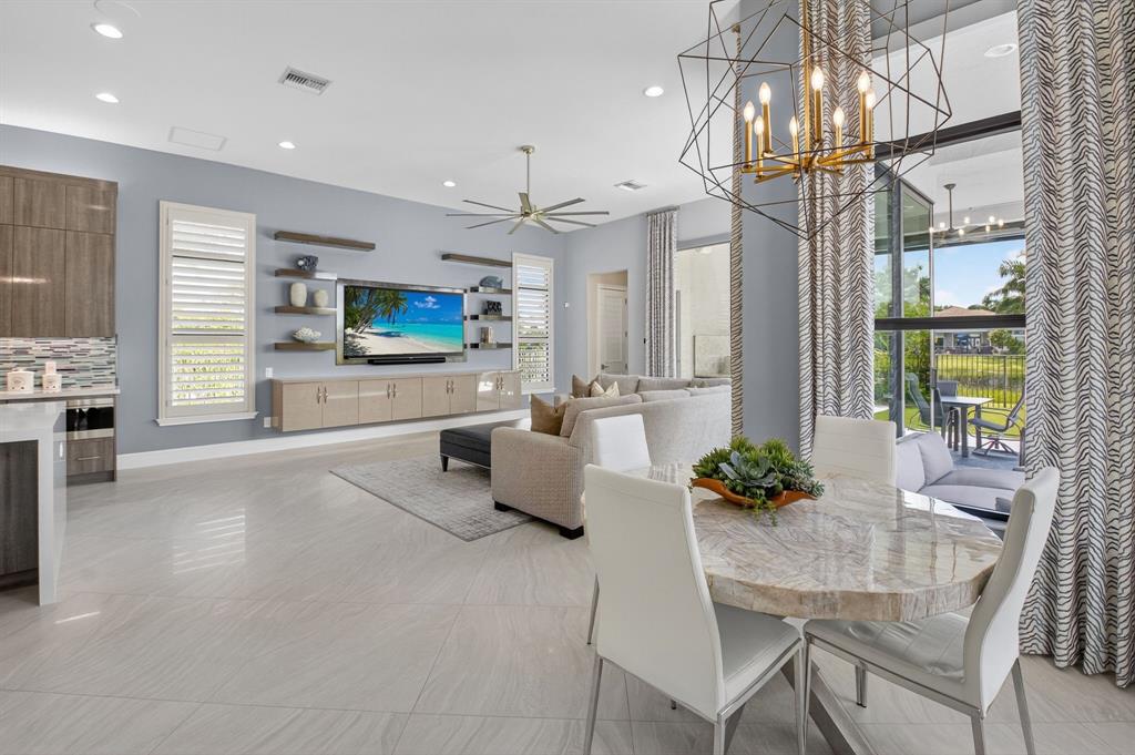 9294 Biaggio Road Boca Raton, FL 33496 - Photo 22 of 80 a living room with furniture a chandelier and a flat screen tv