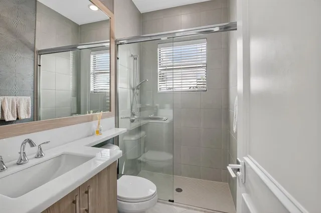 a bathroom with a toilet a sink and mirror