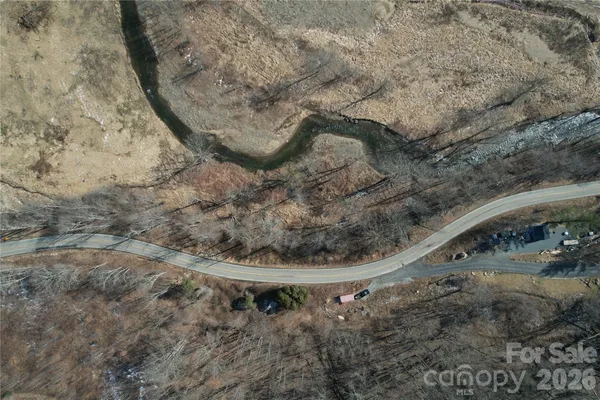 a view of a dry yard with lots of bushes