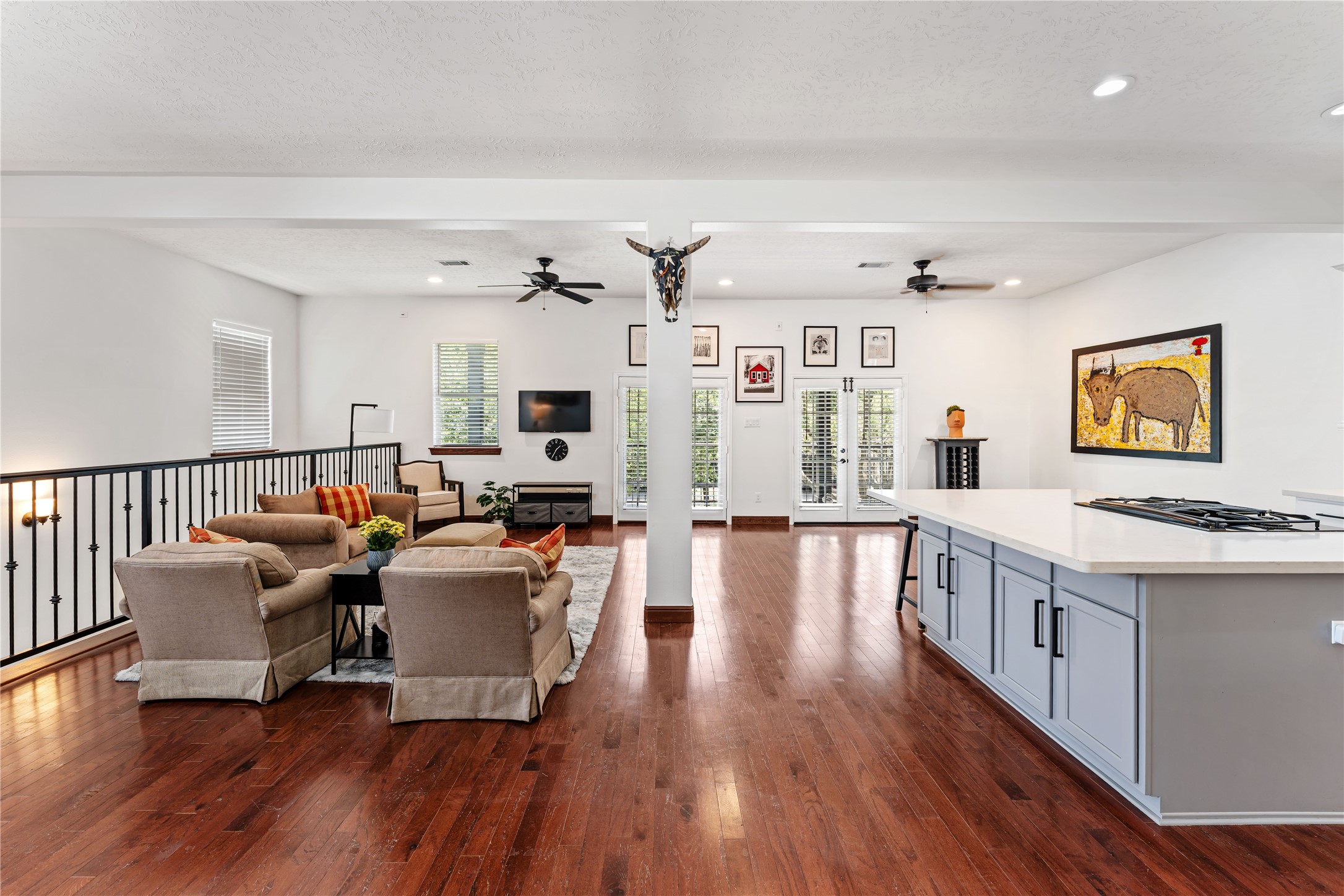 415 West 8th Street Houston, TX 77007 - Photo 21 of 39 Designed for both everyday living and effortless entertaining, the expansive open-concept layout seamlessly connects the kitchen, dining, and living areas. Rich hardwood flooring, soaring ceilings, and abundant natural light create an inviting atmosphere, while French doors open to the oversized covered balcony, extending your living space outdoors.