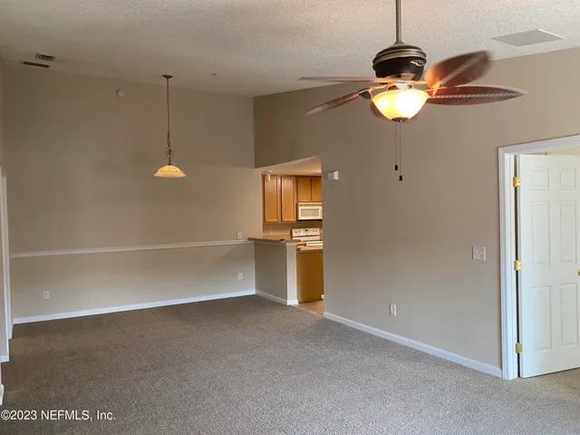 a view of a room with an empty space and wooden floor