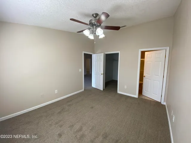 a view of an empty room with a ceiling fan