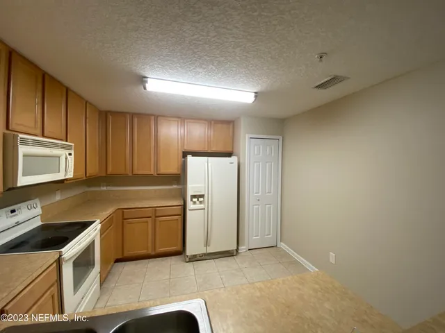 a kitchen with stainless steel appliances granite countertop a refrigerator a stove top oven a sink and dishwasher