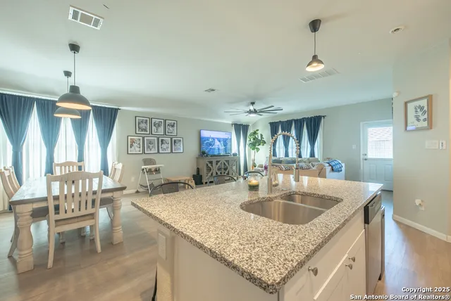 a kitchen with granite countertop a sink a counter and chairs