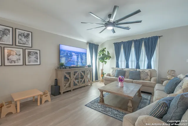 a living room with furniture a flat screen tv and a window