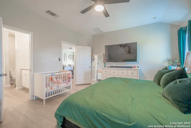 a bedroom with a bed and a flat tv screen on dresser