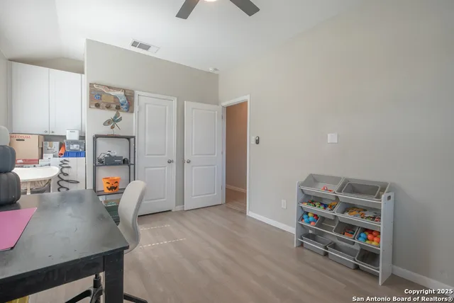 a view of a study room with furniture and wooden floor