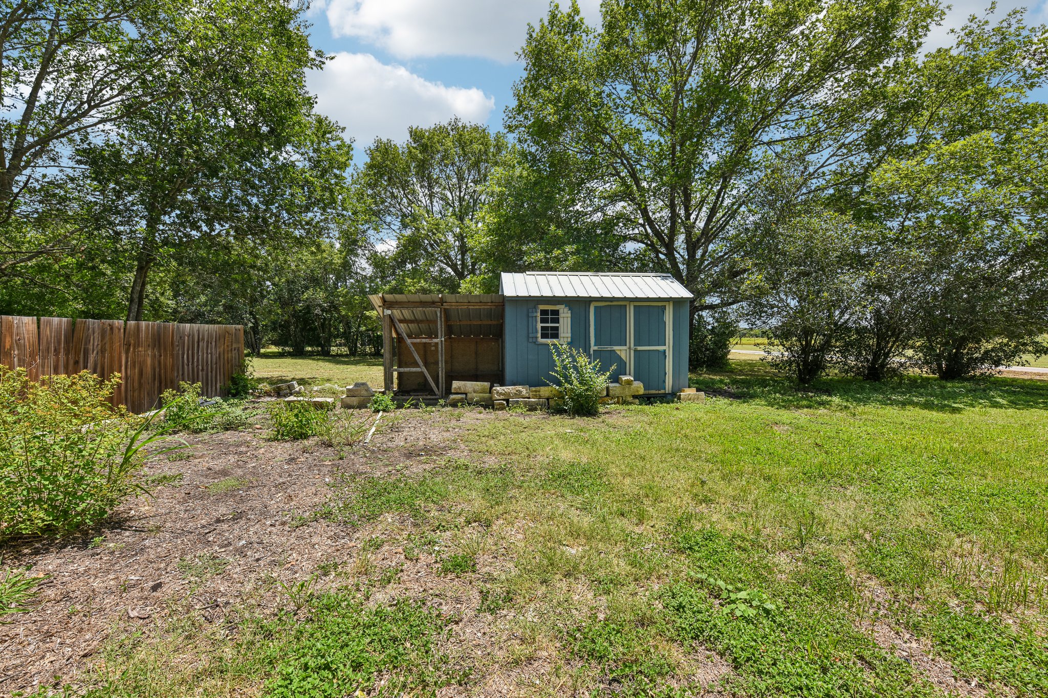 1111 Silent Valley Road Lockhart, TX 78644 - Photo 13 of 14 A quaint blue shed with an attached covered area provides ample outdoor storage and utility.