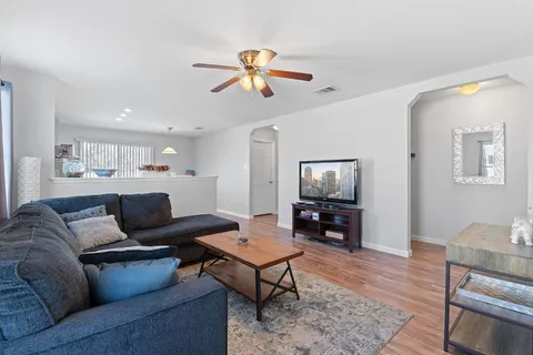 a living room with furniture and a wooden floor