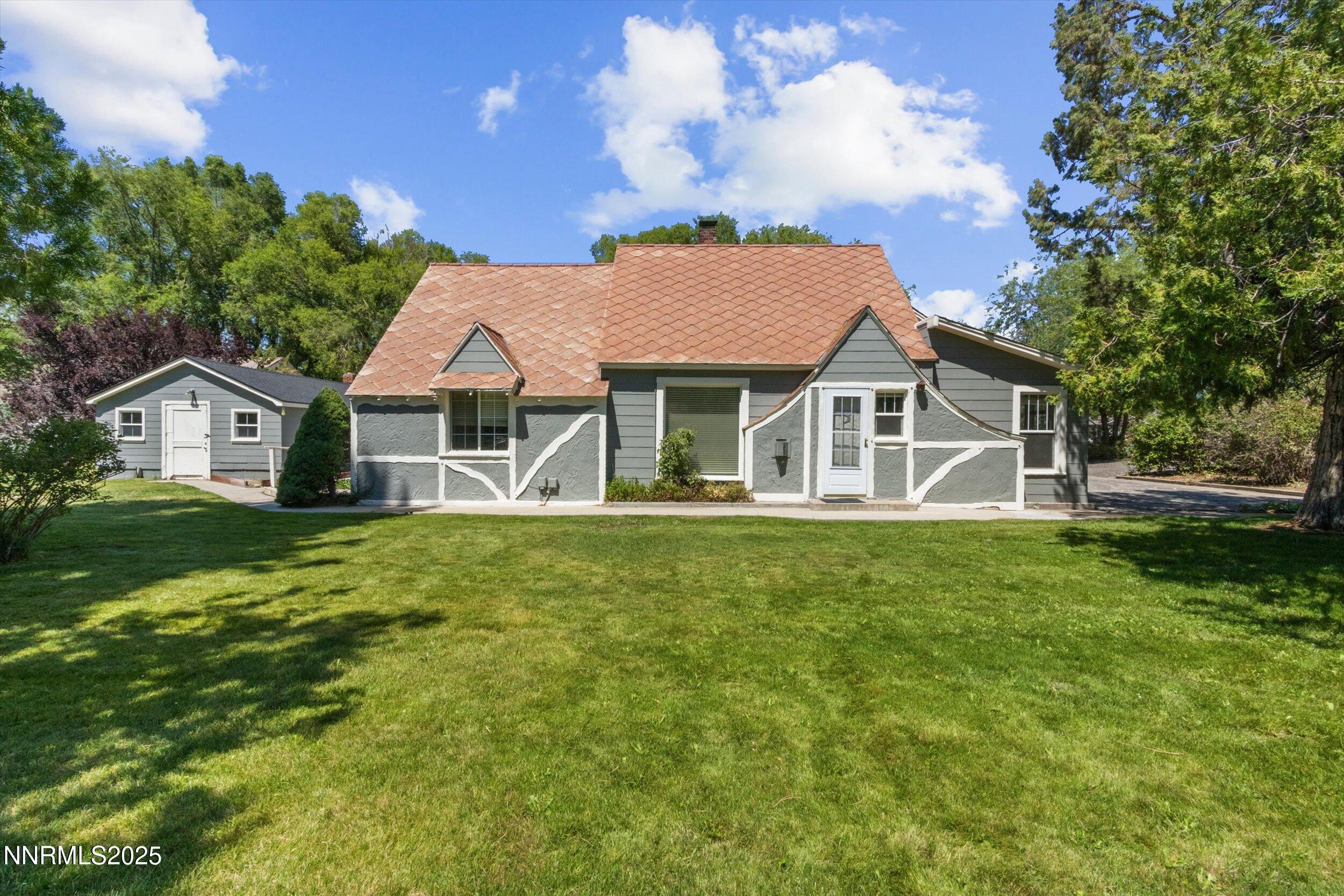 a view of a house with a yard table and chairs