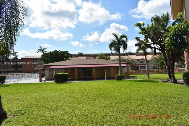 a view of a house with a big yard and large trees