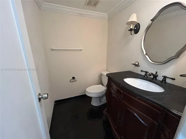 a bathroom with a granite countertop sink toilet a mirror and vanity