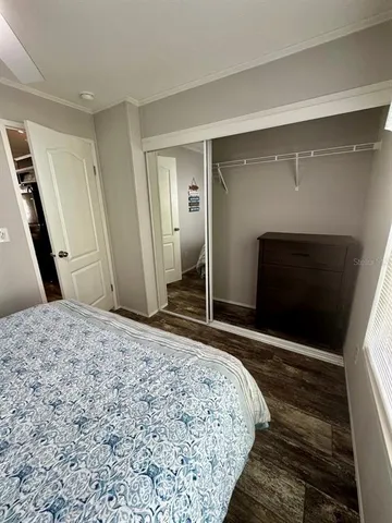 a bedroom with a bed and a mirror on dresser
