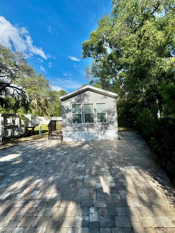 14365 Northeast 252nd Ct Road, Unit 123 Salt Springs, FL 32134 - Photo 22 of 44 a backyard of a house with large trees and parked car