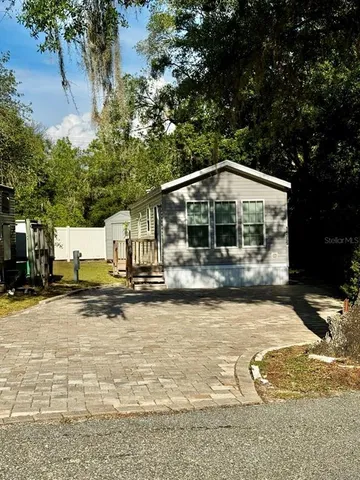 a view of a house with pool and sitting area