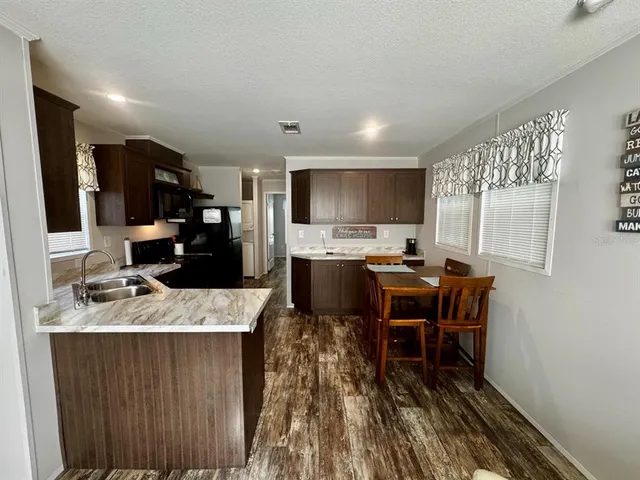 a kitchen with kitchen island granite countertop a sink cabinets and stainless steel appliances