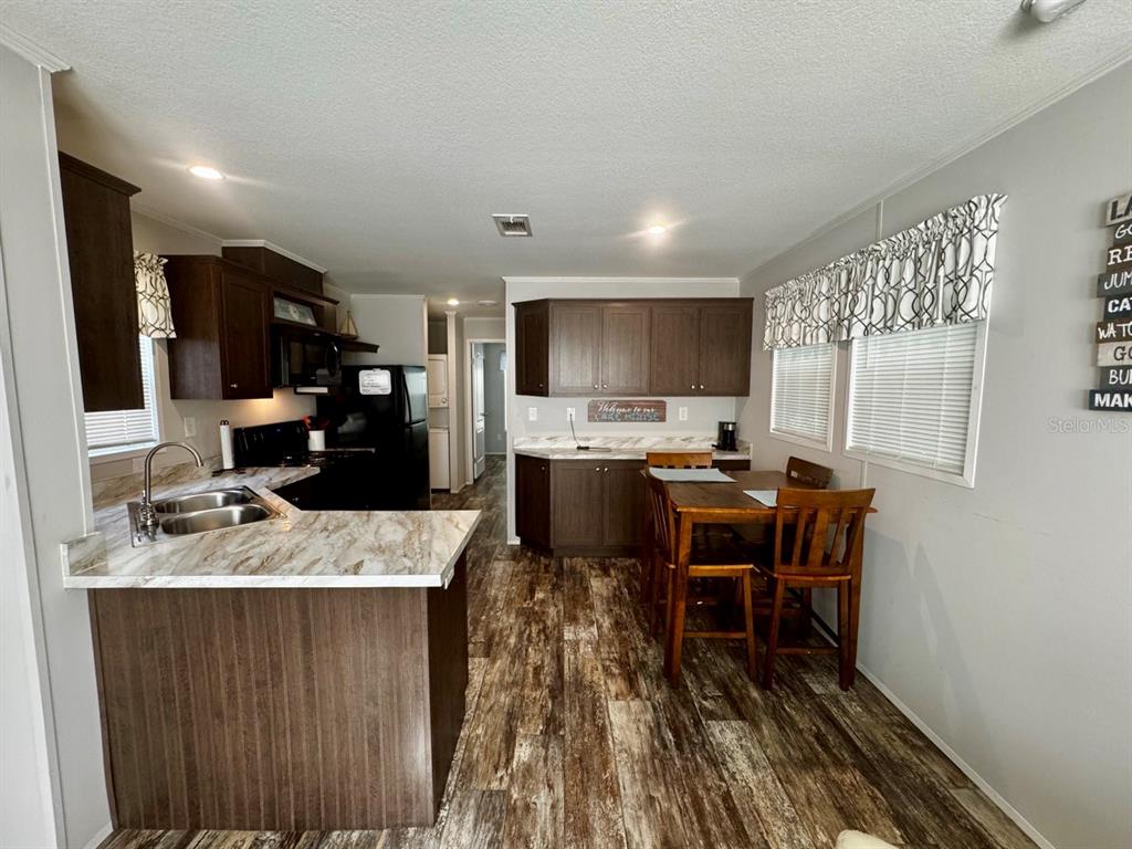 14365 Northeast 252nd Ct Road, Unit 123 Salt Springs, FL 32134 - Photo 6 of 44 a kitchen with kitchen island granite countertop a sink cabinets and stainless steel appliances