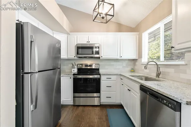 a kitchen with stainless steel appliances a refrigerator sink and microwave
