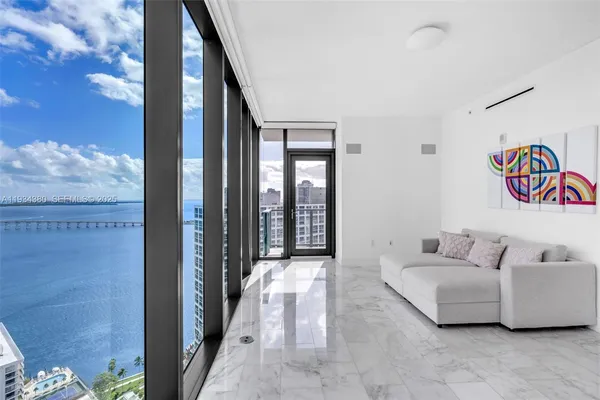a living room with furniture and a floor to ceiling window