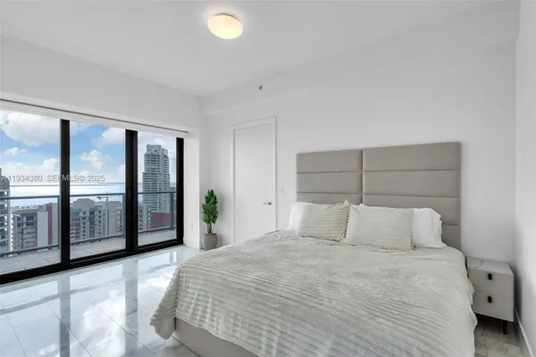 a bedroom with a large bed and a large window