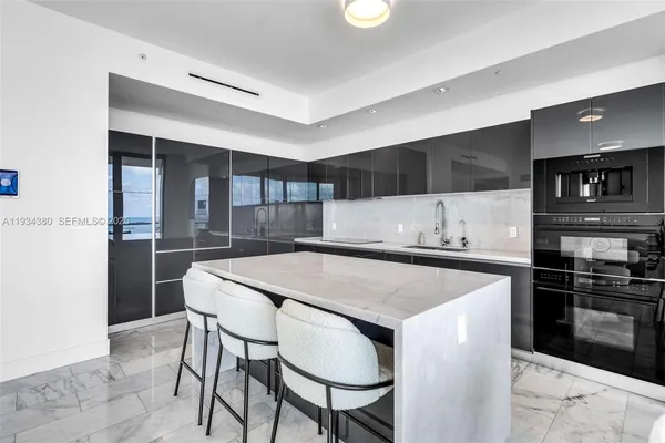 a kitchen with kitchen island a stove and a refrigerator