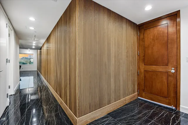 a view of hallway with a large window and wooden floor