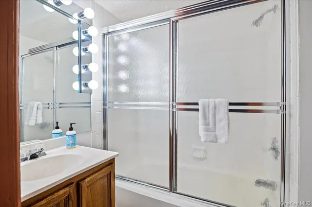 a bathroom with a sink vanity mirror and shower