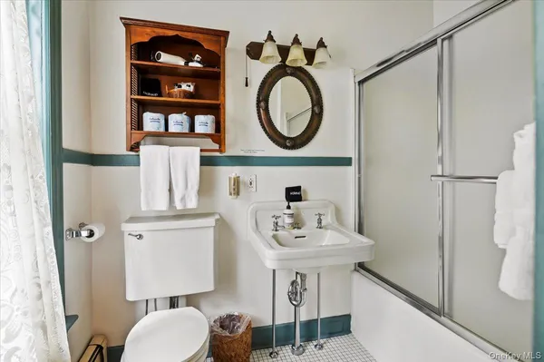 a bathroom with a sink a toilet and a mirror