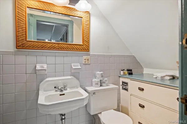 a bathroom with a sink toilet and mirror
