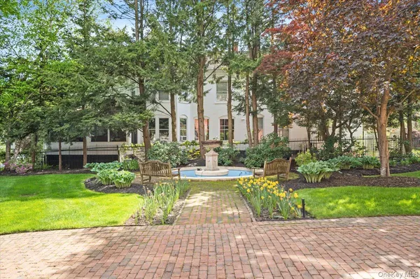a view of a house with garden and a tree