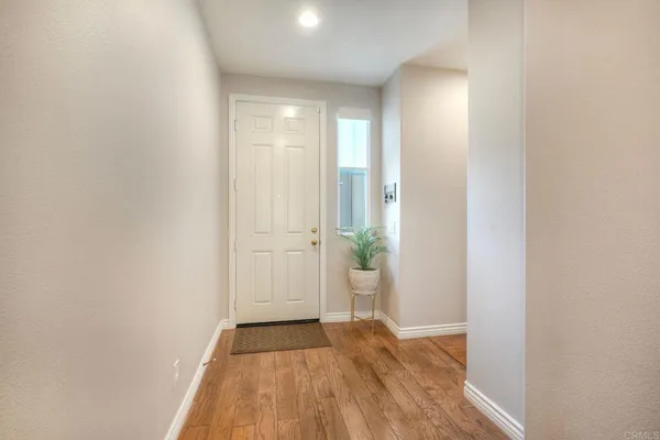 a view of a room with wooden floor and a hallway