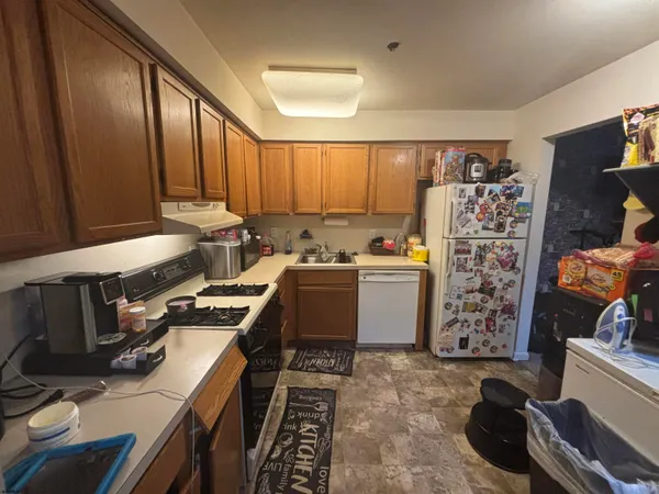 a kitchen with a refrigerator and a stove top oven