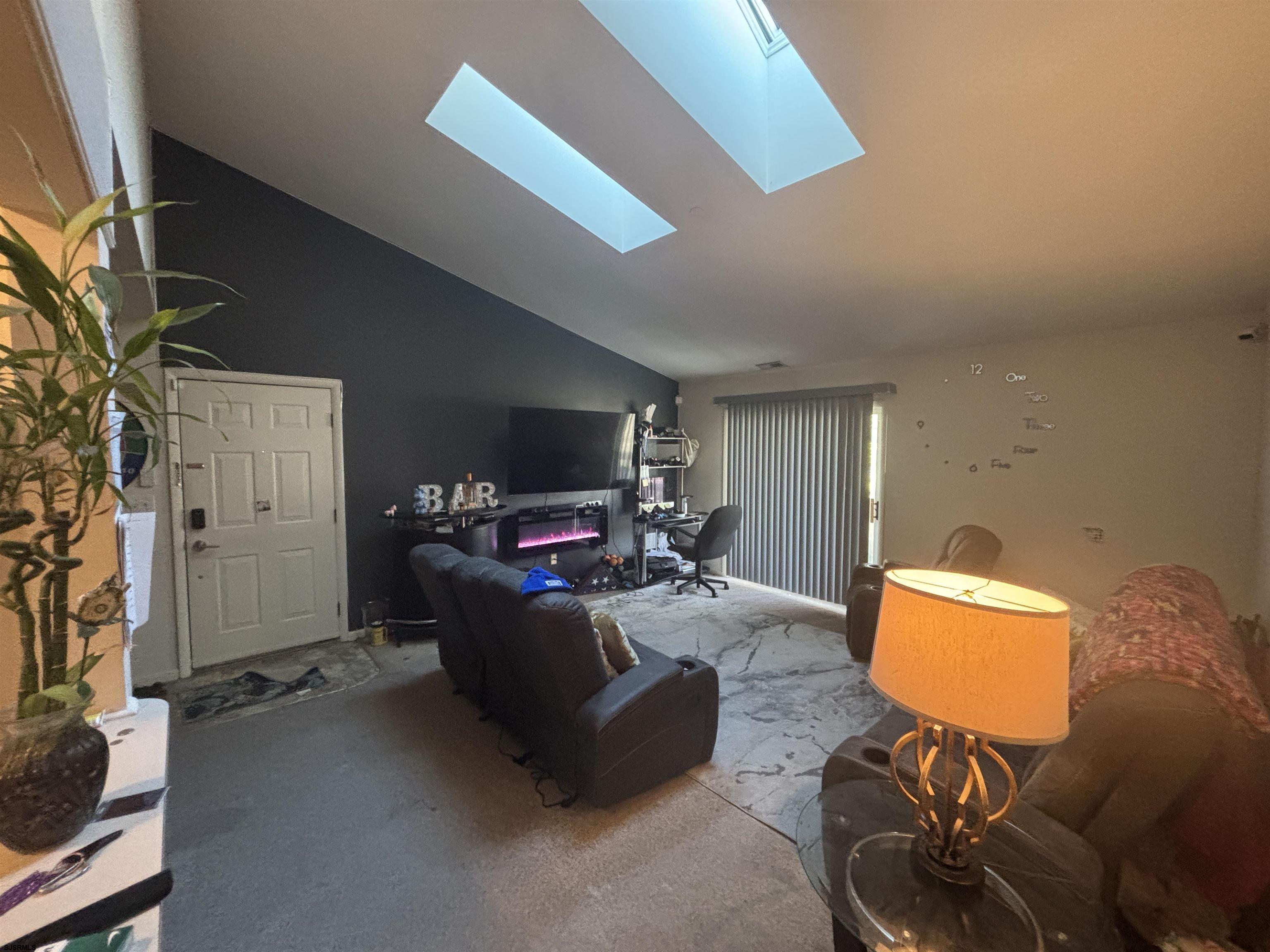 4 Oyster Bay, Unit 4M Absecon, NJ 08201 - Photo 5 of 8 a living room with furniture and a flat screen tv