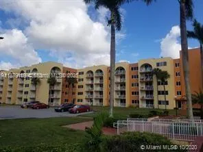 a front view of a building with glass windows and a yard