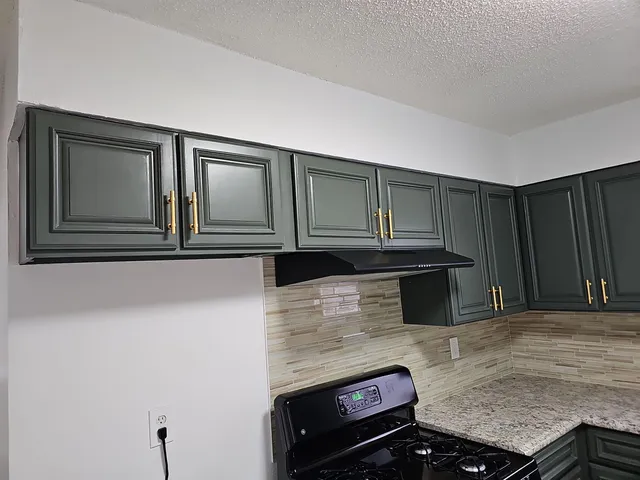 a kitchen with granite countertop a sink and a stove