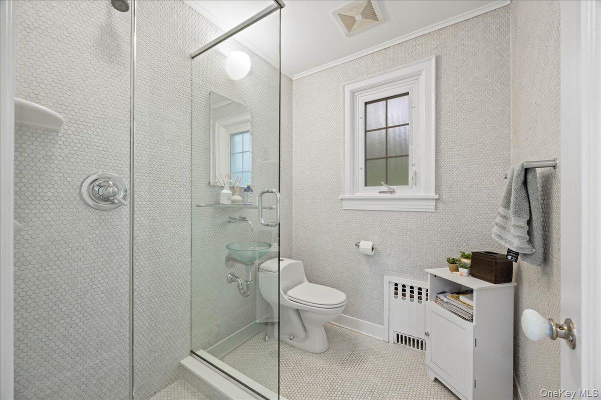 311 Lyncroft Road New Rochelle, NY 10804 - Photo 16 of 39 a bathroom with a toilet a sink and shower